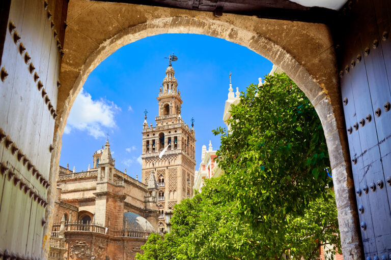 Seville,Cathedral,Giralda,Tower,From,Alcazar,Arch,Door,Of,Sevilla