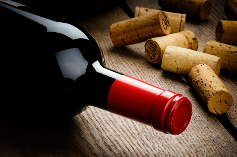 Bottle,Of,Red,Wine,And,Corks,On,Wooden,Table