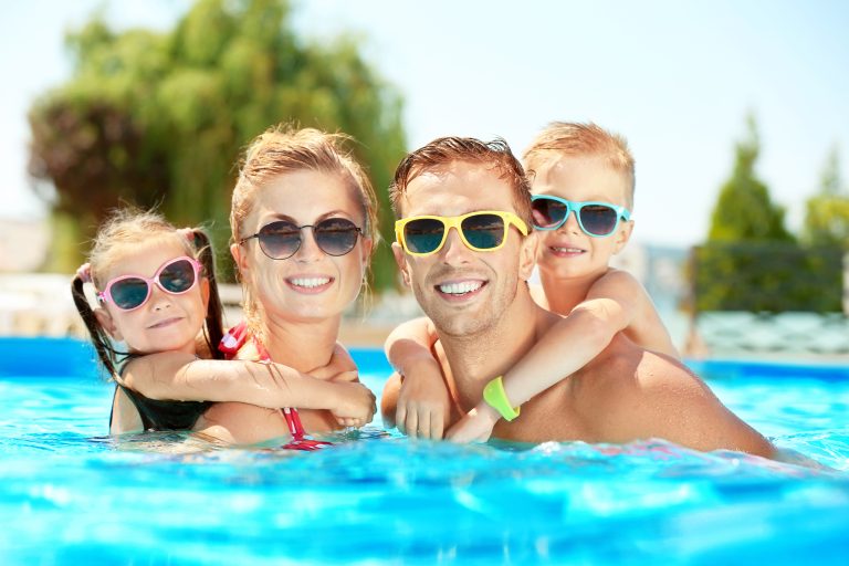 Happy,Family,In,Swimming,Pool,At,Water,Park