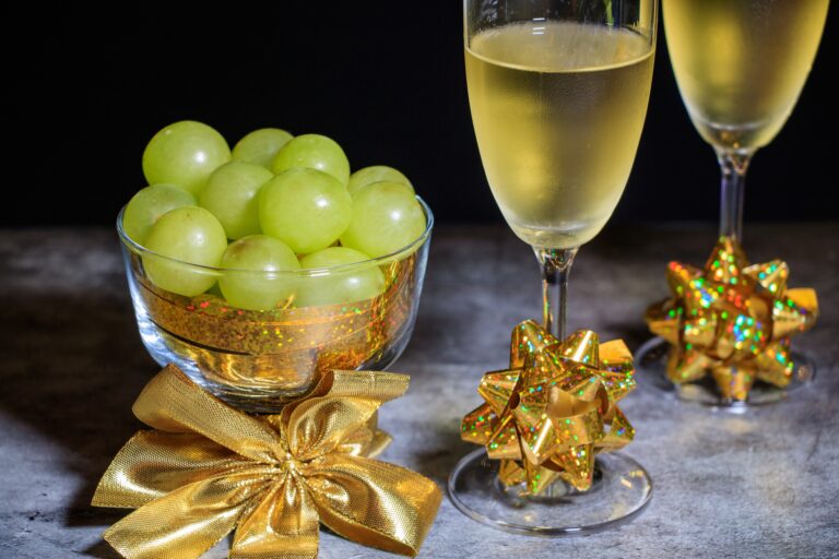 Two,Glasses,Of,Champagne,With,Twelve,Grapes