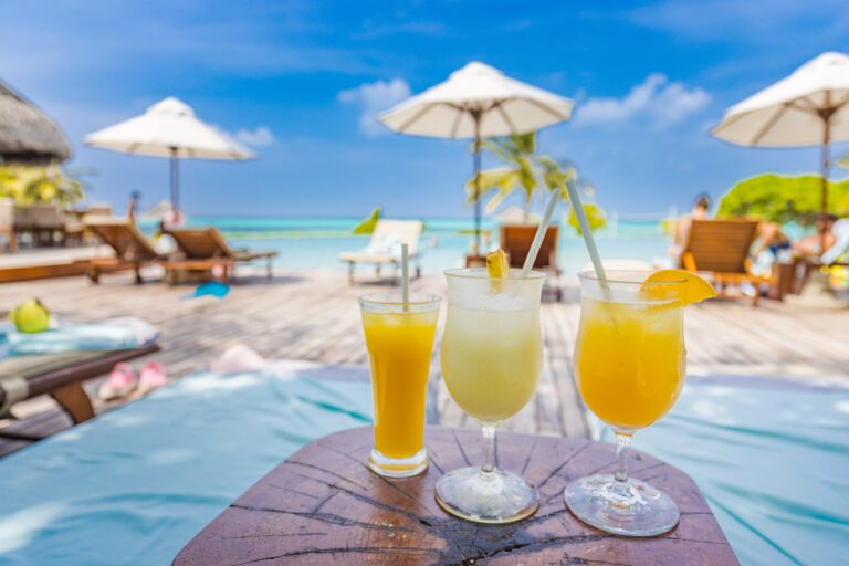 Colorful,Cocktails,On,Luxury,Beach,Resort.,Blurred,Poolside,,Chairs,,Beds