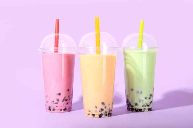 Plastic,Cups,Of,Tasty,Bubble,Tea,On,Purple,Background