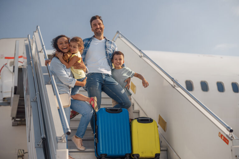 Portrait,Of,Happy,Family,Of,Four,Getting,Off,The,Plane