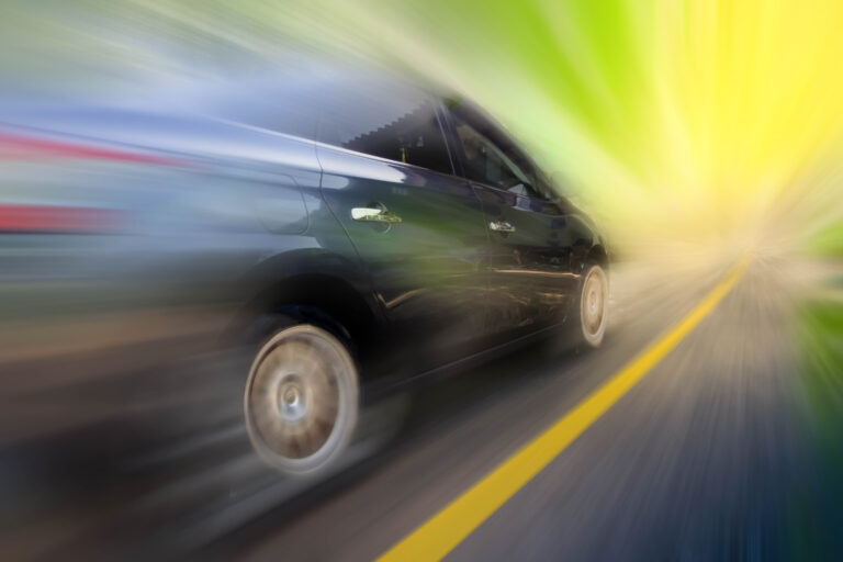 Abstract,Blur,Black,Speeding,Car,On,The,Road,At,Sunset